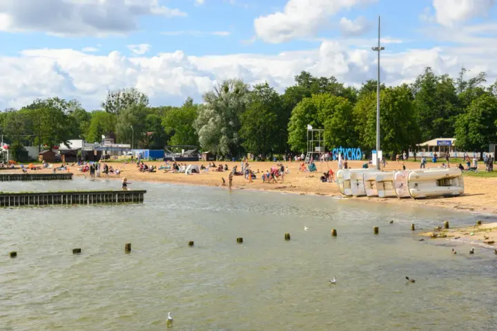 Rodzinny wypoczynek na piaszczystej plaży nad jeziorem. Idealne miejsce, gdzie na Mazury z dzieckiem, by cieszyć się słońcem i wodą.